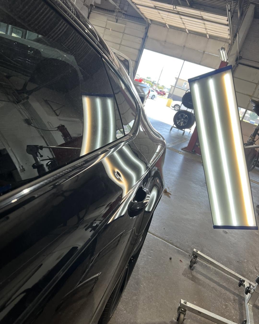 Hail dent interrupting the repair light reflection on an Audi door before repair